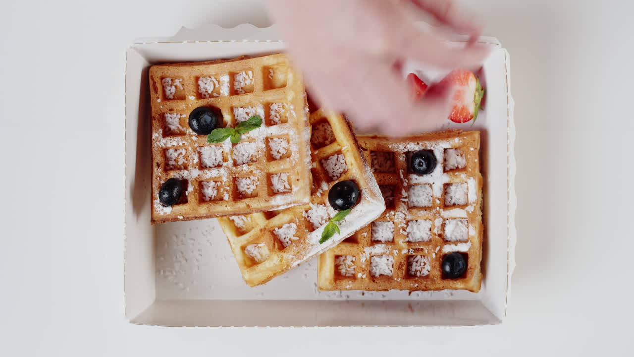 Tampak Atas: Tangan Menghias Wafel dengan Beri Segar dan Mint