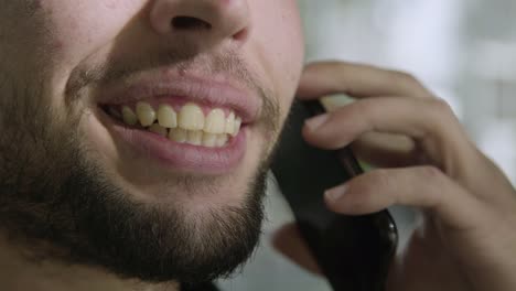 Closeup-shot-of-smiling-man-talking-on-smartphone.