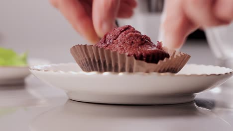 grabbing tasty chocolate cupcake pieces with fingers while cooking a delicious dessert in a bakery close-up shot