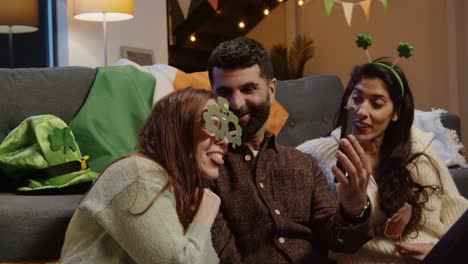 friends dressing up with irish novelties and props at home posing for selfie celebrating at st patrick's day party 3