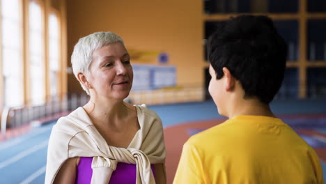 senior woman talking to boy indoors