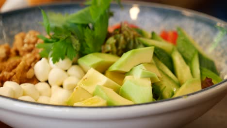 healthy avocado salad with mozzarella, tomato and cucumber