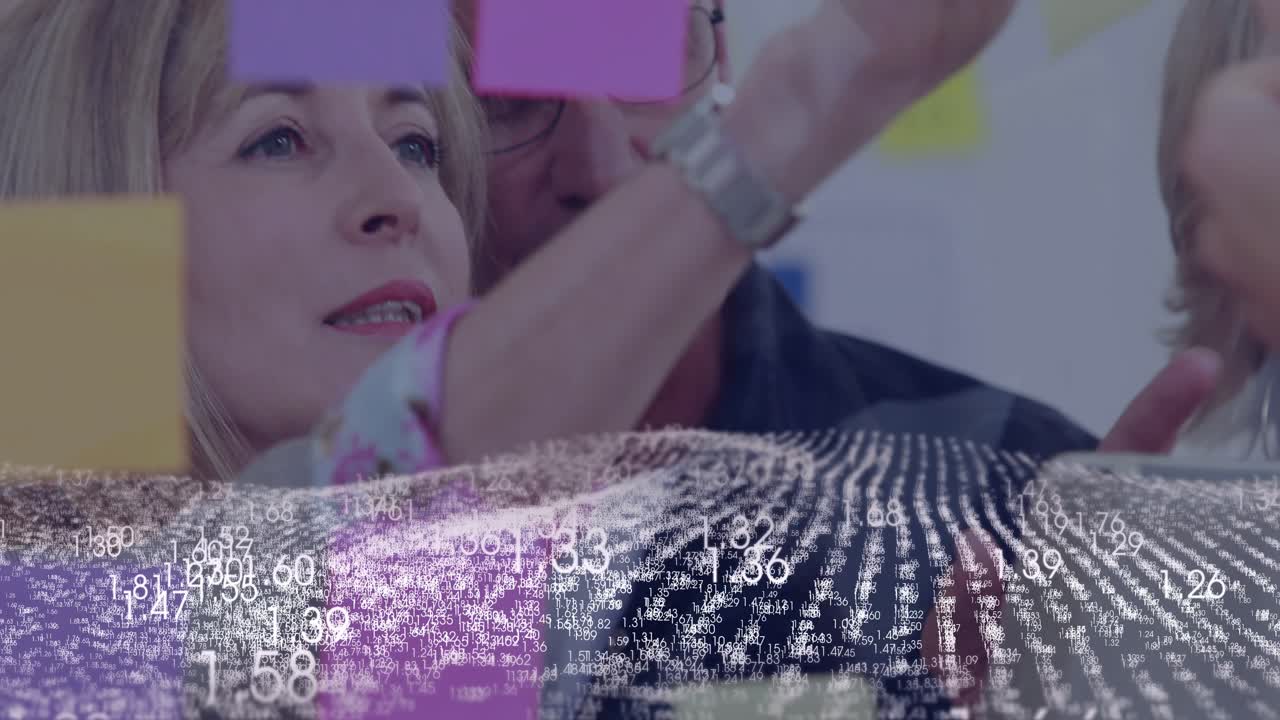 Donna che posiziona una nota rosa, uomo che guida, nuvola di dati che si sposta su un vetro trasparente in un workshop aziendale