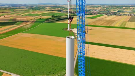 engineer inside wind turbine tower during assembly assisted by crawling crane