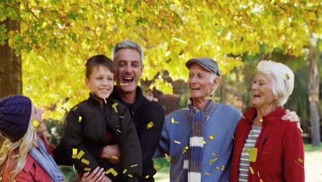 confetti animation over happy family enjoying time together in autumn park