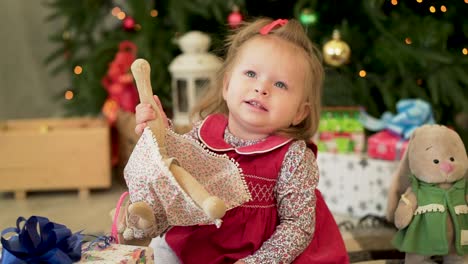 la niña juega con un regalo de navidad.