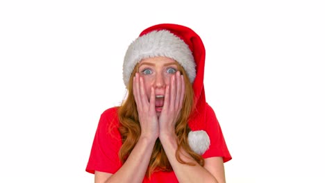 suprised woman in stanta claus hat standing with shock on her face on white background