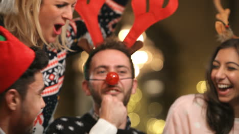 grupo de amigos disfrutando de bebidas navideñas en un bar