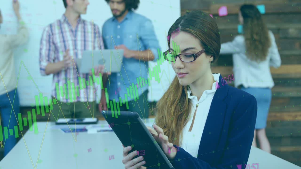 Using tablet with financial charts, businesswoman working with colleagues in office