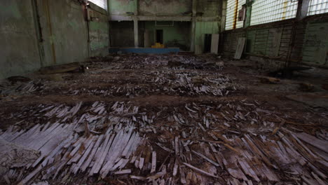 Broken-floor-of-basketball-court-in-Pripyat-school,-tilting-up-view