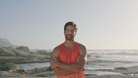 Retrato-De-Un-Hombre-Atractivo-Y-En-Forma-Sonriendo-Junto-Al-Mar-Tocando-La-Barbilla-Con-Confianza