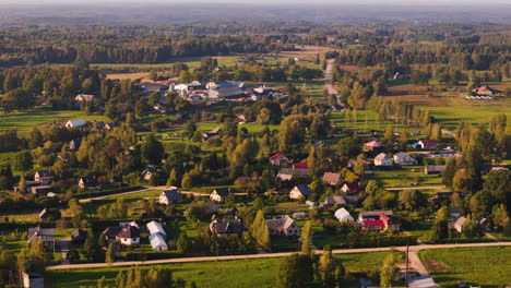 drone footage showcasing the rural village of augšlīgatne, latvia, with lush greenery and scattered homes.