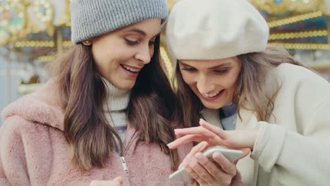 Video-of-two-friends-on-a-Christmas-market-browsing-phon