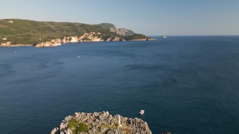 Aerial-pullback-showcases-sharp-textured-rock-cliffs-and-windswept-waters-of-Corfu-Greece