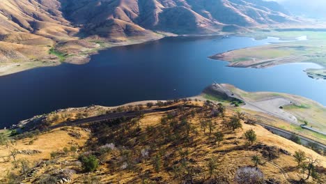 drone-video-flying-over-a-drought-effected-lake-with-cars-driving-on-a-nearby-road