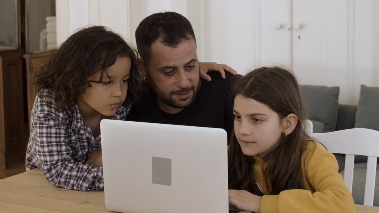 padre soltero estudiando con niños usando una computadora portátil.