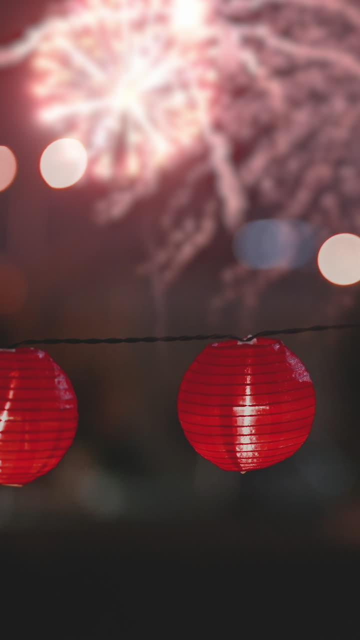 Glowing Red Paper Lanterns with Fireworks at Night