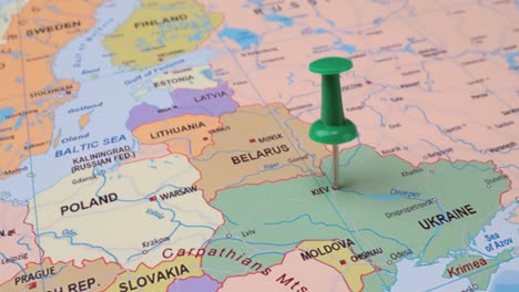 ucrania - concepto de viaje con alfiler verde en el mapa del mundo. el punto de ubicación en el mapa apunta a kiev, la capital de ucrania.