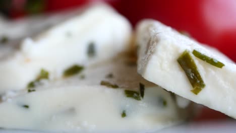 slices of white cheese with herbs and tomatoes