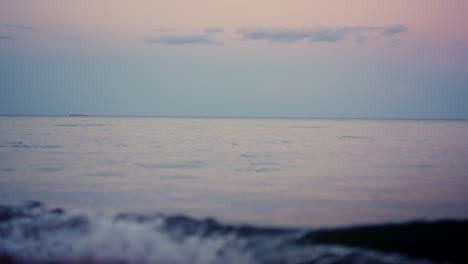 calm ocean surface horizon at pink sky in cold morning dawn. sea water waves