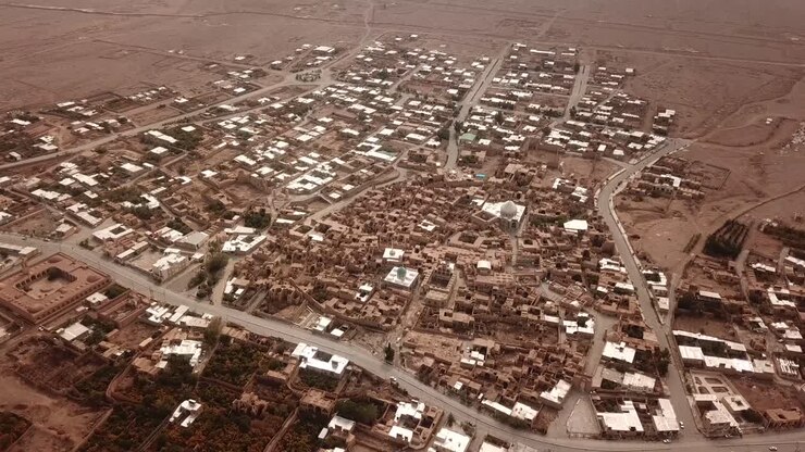 Pomegranate garden and historical desert old city map drone aerial view of civilization in Iran local people life brown color architecture and concept of eco resort lodge in UTAH in a hazy day dust