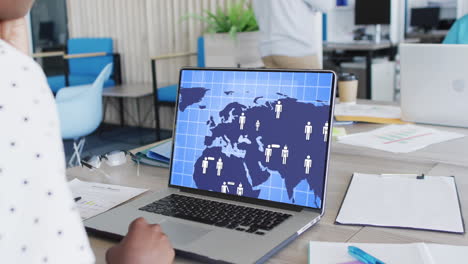 mujer de negocios afroamericana en el uso de computadora portátil con procesamiento de datos en la pantalla en la oficina