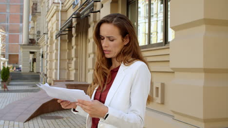 mujer de negocios molesta leyendo documentos al aire libre. mujer de negocios triste