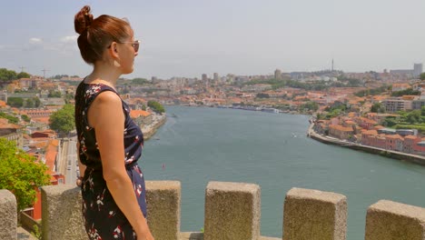 Young-tourist-standing-on-platform-overlooking-the-Douro-river-in-Porto-while-on-holiday