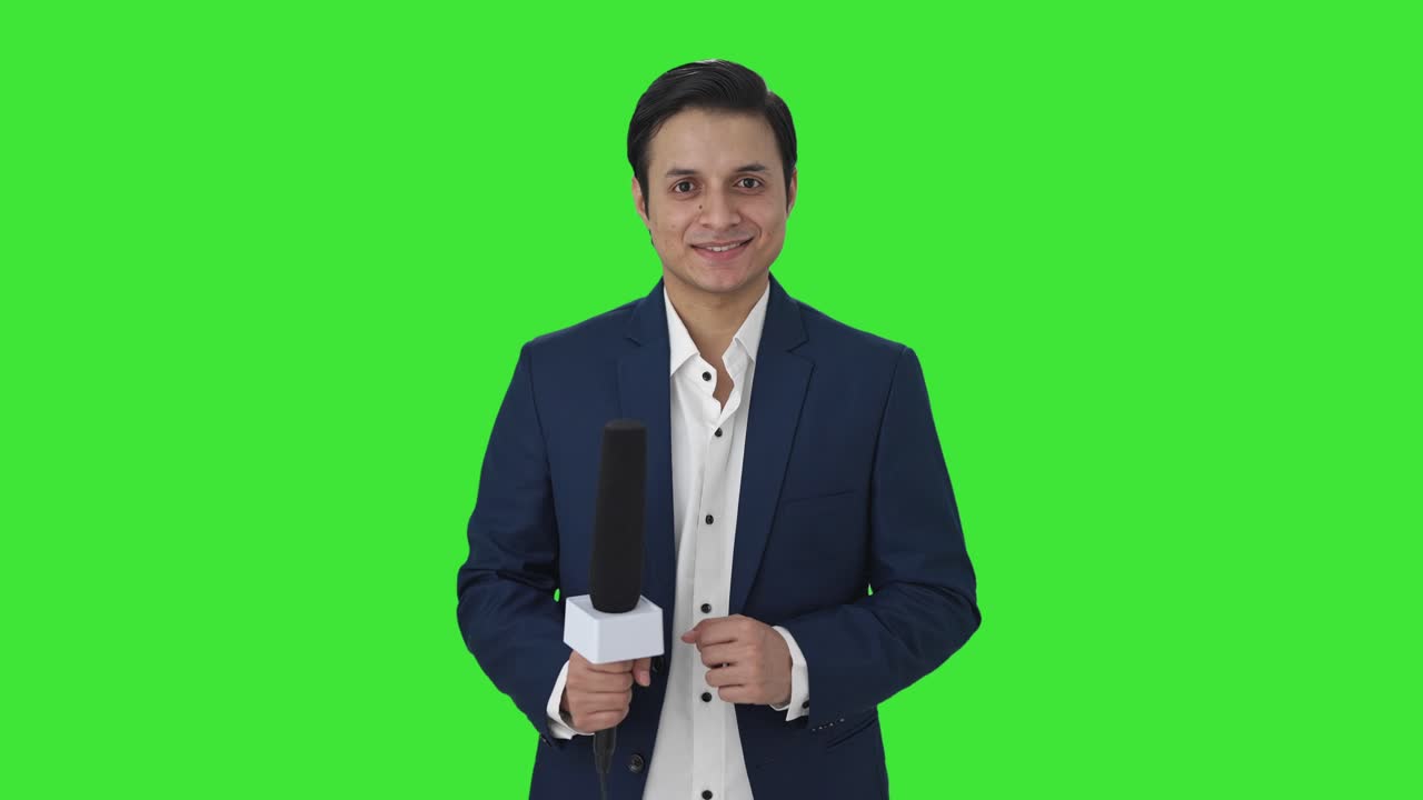 Happy Indian reporter smiling to the camera Green screen