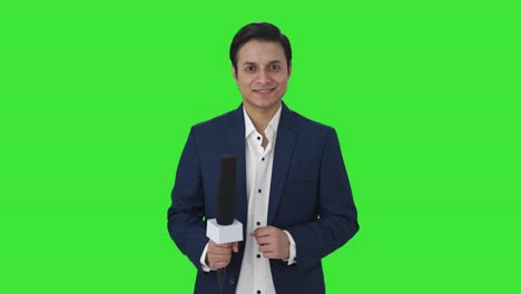 happy indian reporter smiling to the camera green screen