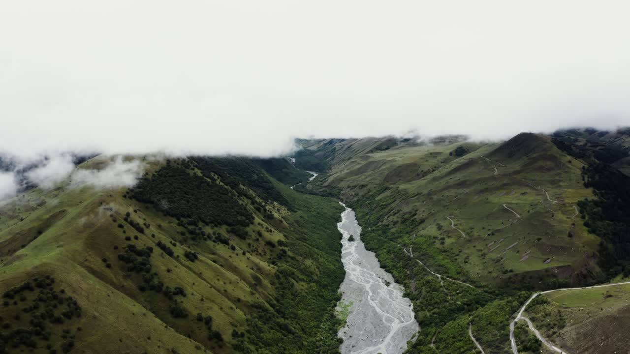 valle de montaña con río y nubes