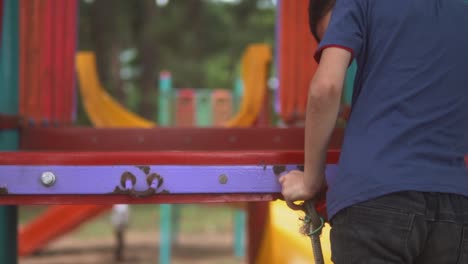 toma estática en cámara lenta de un niño con una camisa azul en un patio de recreo
