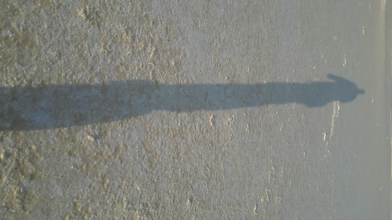 건조 한 소금 호수 표면 에서 고 있는 사람 이나 실루 의 긴 그림자