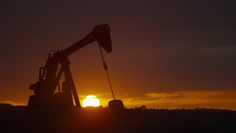 Animation-of-oil-pump-working-over-sunset-and-landscape-in-background