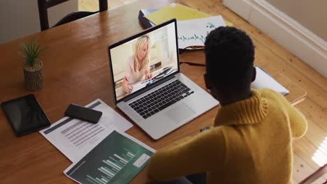 african american female teacher using laptop on video call with female student