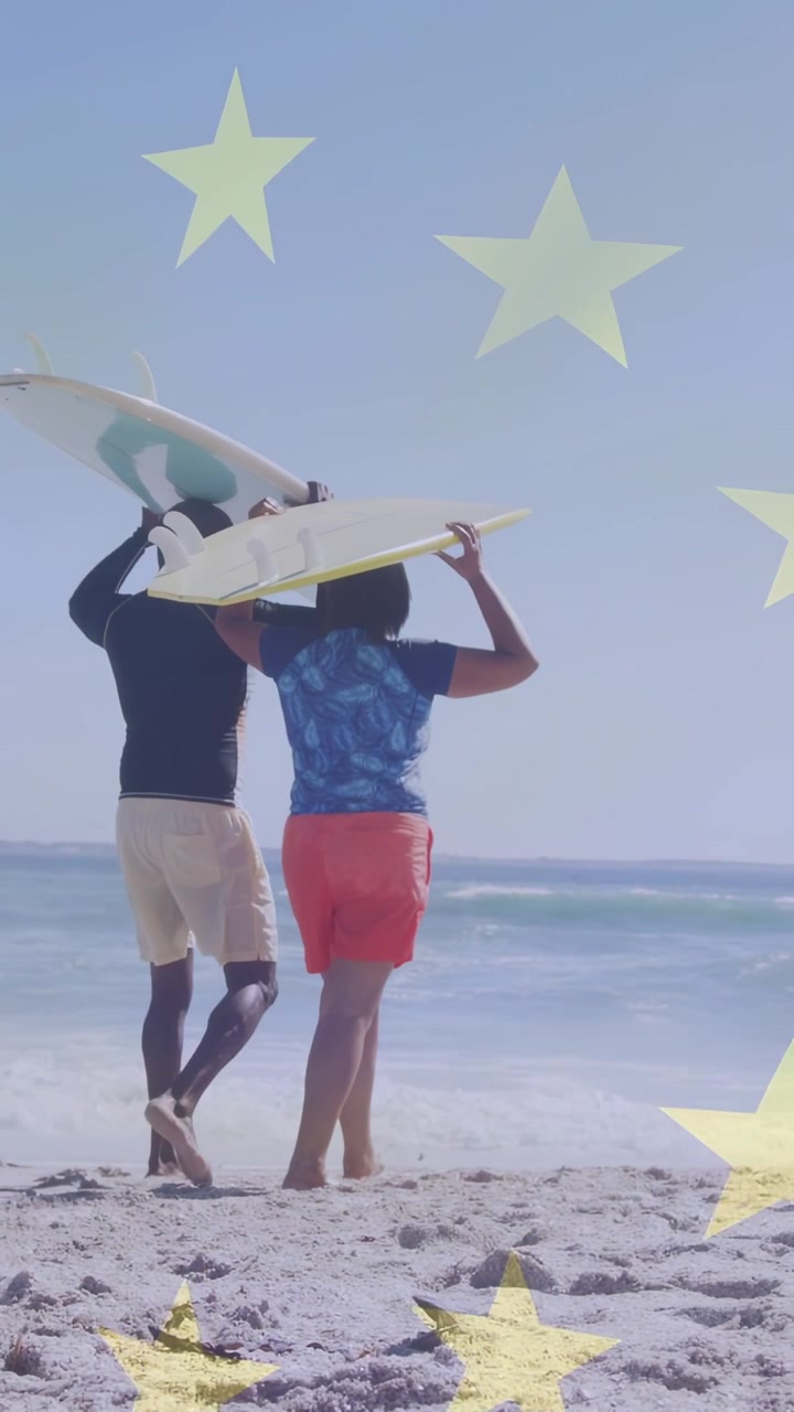 Vertical video: Man and woman shifting grip lifting board walking to surf yellow stars overlaying