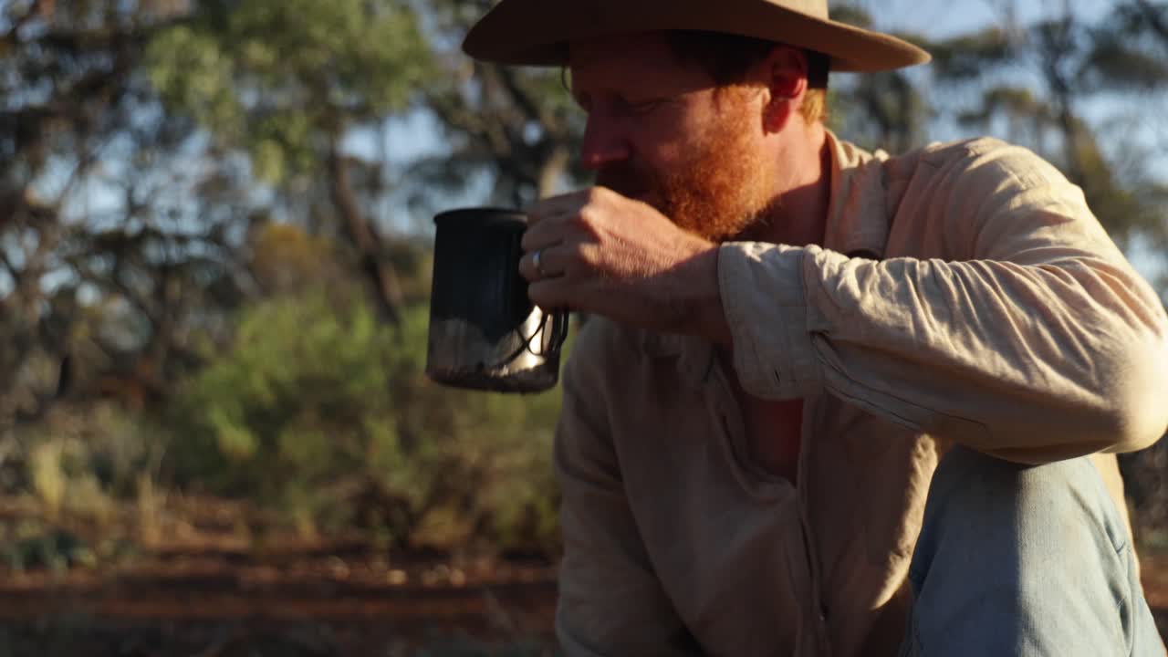 una foto de cerca de un bosquilano australiano fumando una pipa de tabaco vintage en el bosque