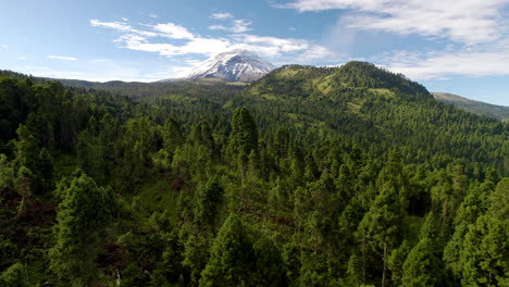 backwards drone shot showing the snowy top of the popocatepetl volcano in mexico city