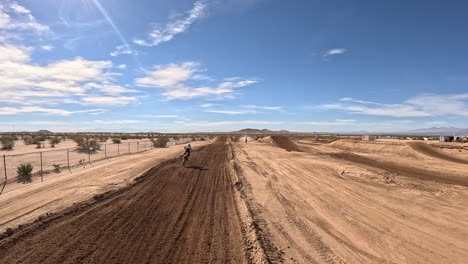 motorcycle stuntman speeds down the dirt track and executes a perfect jump - first-person view drone