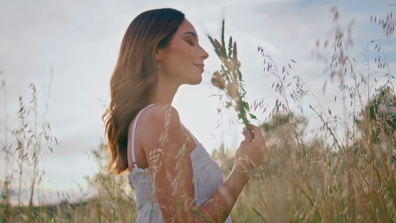 Carefree lady standing field enjoying freedom closeup. Girl holding wildflowers