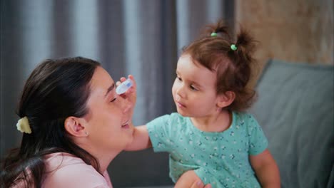 A Heartwarming Interaction Between a Mother and Her Toddler as They Share Joyful Moments in a Cozy Living Room Environment