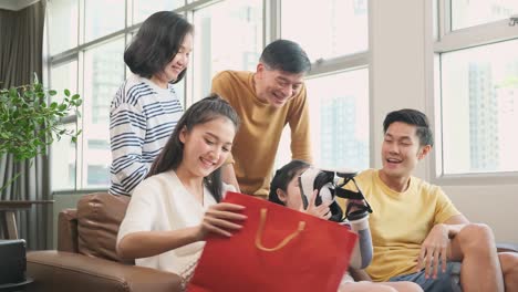 happy asian family grand parent and parent giving birthday present to her lovely daughter at living room home interior background