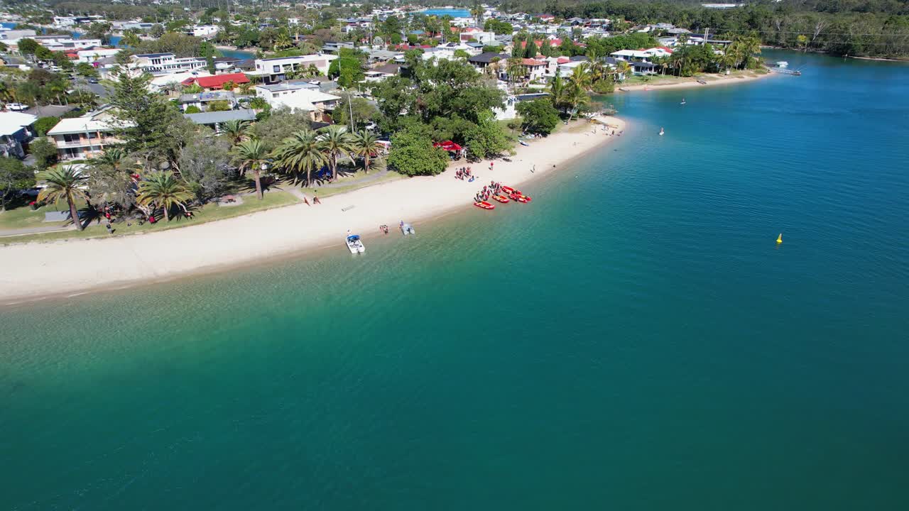 오스트레일리아 즐랜드의 탈레부드게라 크리크에 있는 모래 해변에 있는 관광객들과 배들