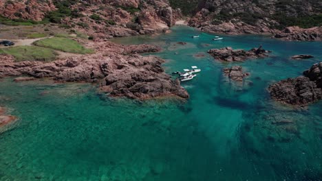 aerial view from above of particular rocky area of sardinian sea in italy with boats anchored in place of protected nature while enjoying summer season