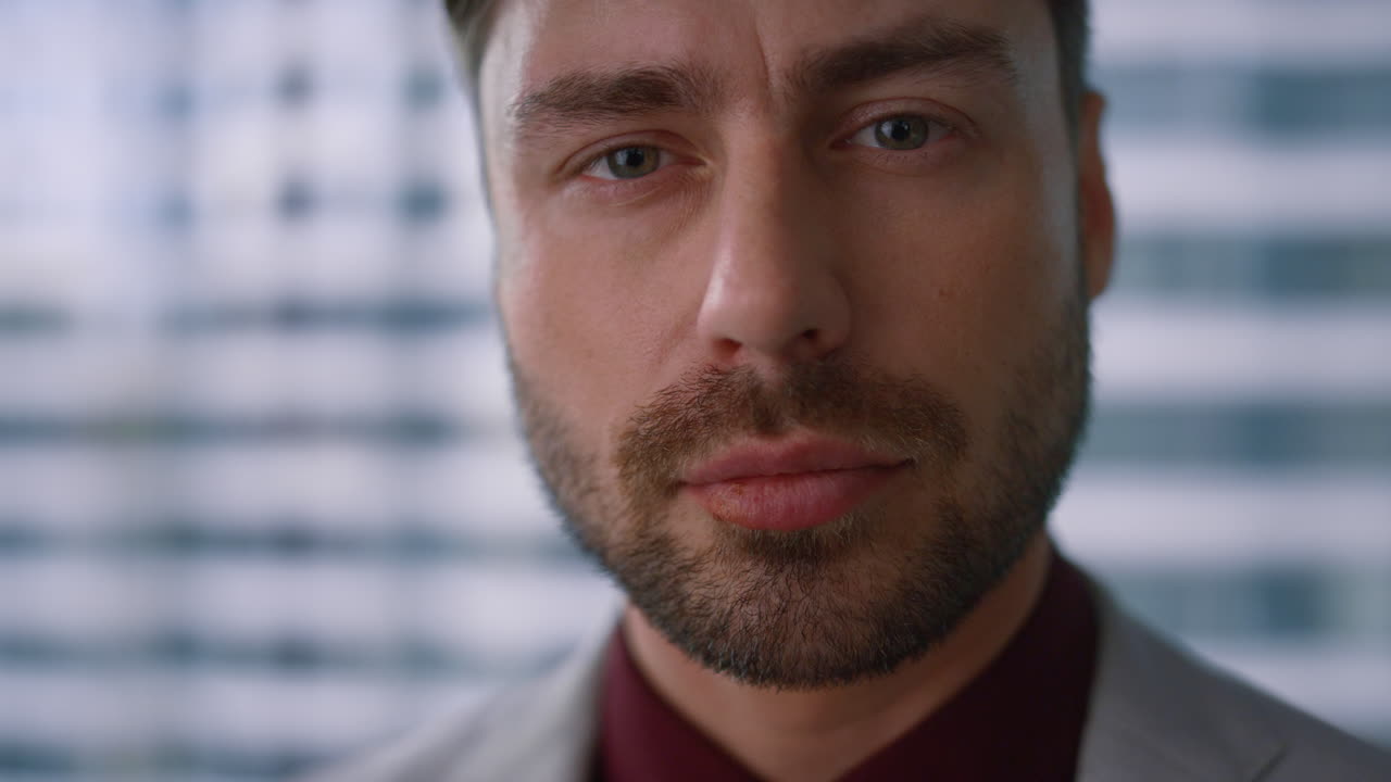 красивый бизнесмен смотрит в камеру.