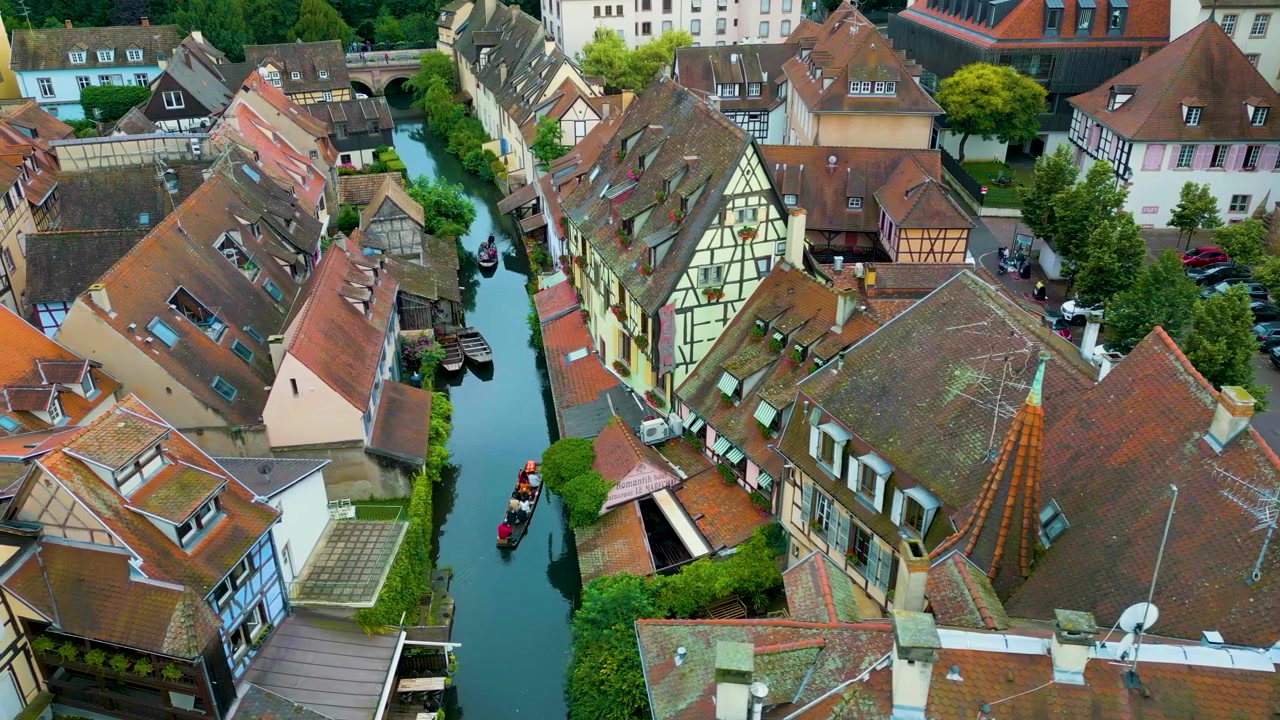 Video drone 4K aereo di turisti in barca sul fiume Lauch nella zona della Piccola Venezia a Colmar, Francia.