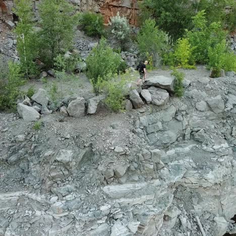 aerial view of a tourist walks along the rocky shore of a lake. traveler on the cliff. camping season