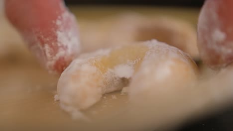 close-up of a baker placing a freshly made vanilakipferl cookie on a cutting board