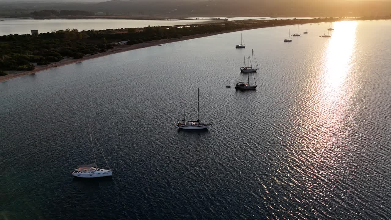 Navarin,Messinia,Gialoval Beach,Aerial forward towards the sun along the Gialova Beach and Lagoon.Lot of sailboats on anchor at the calm bay during sunset
