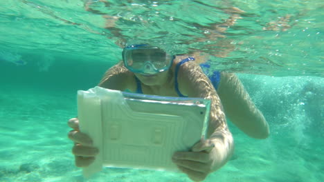 woman diving with pad to make a good underwater shot